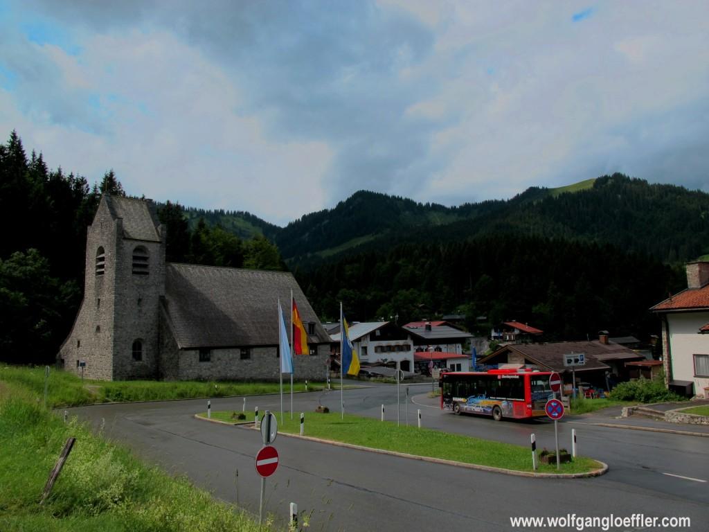 Kirche im Dorf Spitzingsee mit Bergen im Hintergund