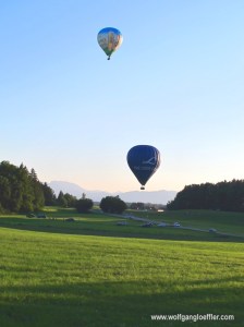 Zwei Ballons starten von einer Wiese