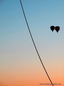 Zwei Ballone schweben dicht beieinander in den Sonnenuntergang