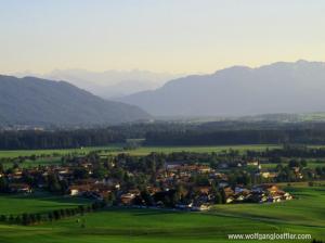 Luftaufnahme eines Dorfes vor imposanter Bergkulisse