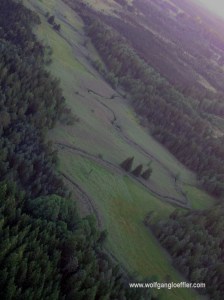 Blick von oben auf eine Wiese mit einem Bach