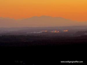 Panoramablick über das Voralpenland mit Alpen im dramatischen Sonnenuntergang