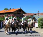 Vier Frauen in Dirndl reiten in einem Umzug