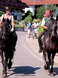 Ein Pärchen reitet bei einem Umzug