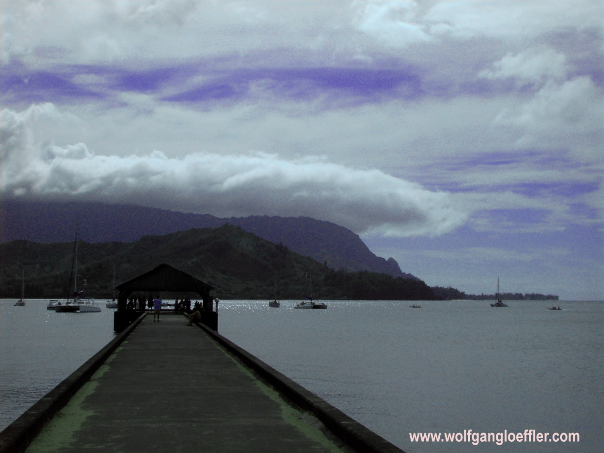 Ein Pier ragt in die Hanalei Bucht mit Blick auf die Berge