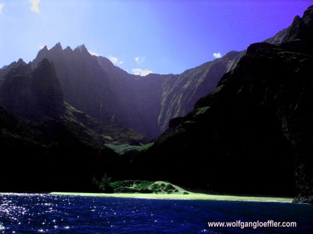 beautiful beach in front of steep cliffs, seen from the ocean