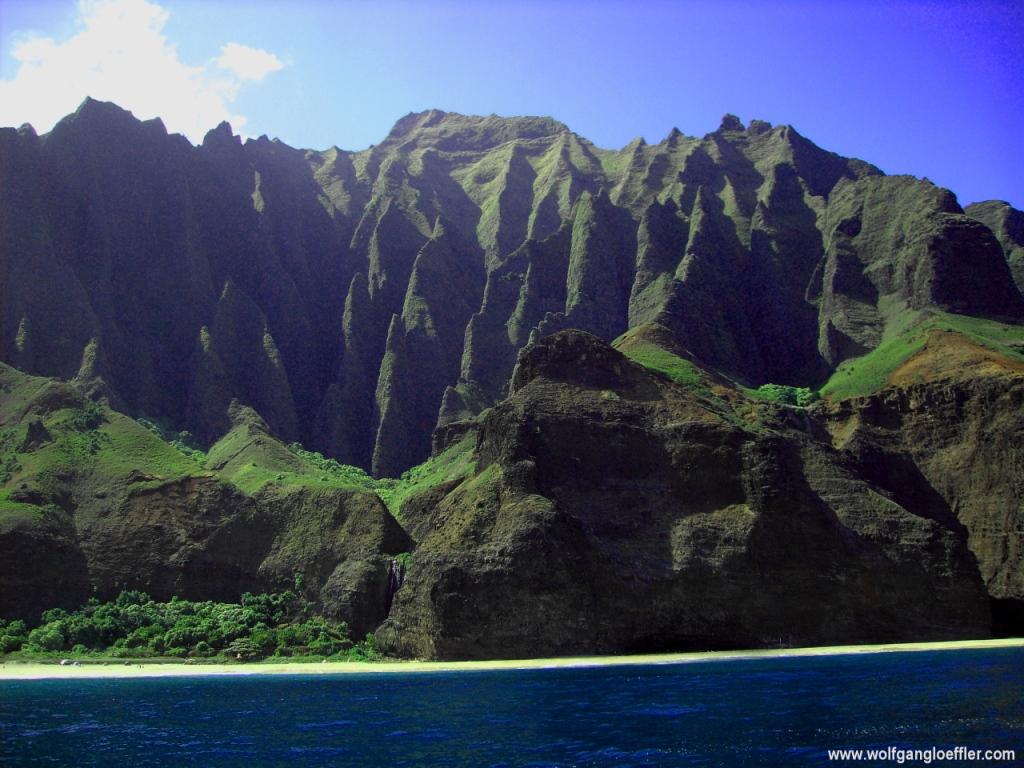 Tal umrahmt von Klippen vor blauem Meer