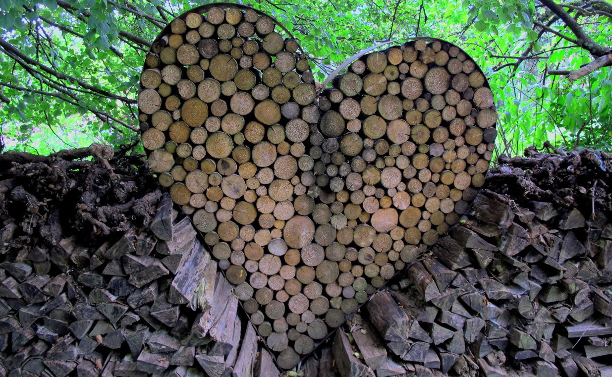 Ein herzförmiger Metallrahmen ist mit Holzscheiten gefüllt
